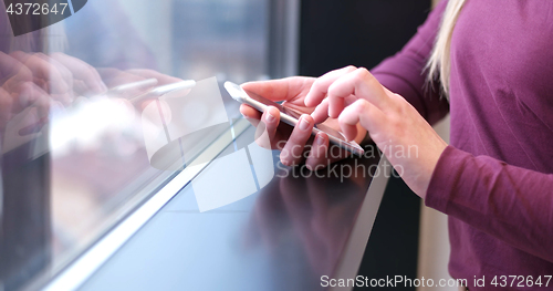 Image of Close up of business woman using cell phone in office interior