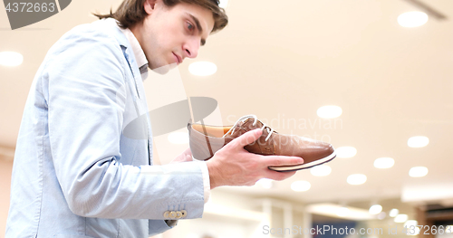 Image of Man Chooses Shoes At Shoe Store