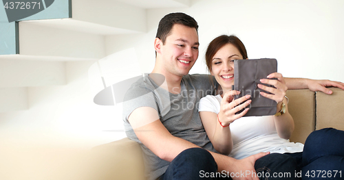 Image of Young Couple using digital tablet at home