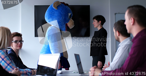 Image of boss dresed as bear having fun with business people in trendy of