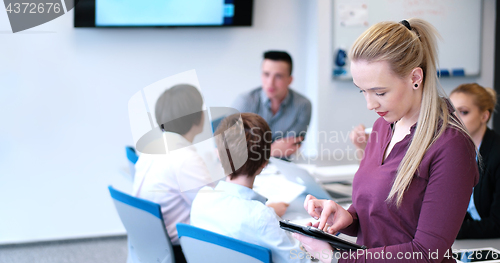 Image of Pretty Businesswoman Using Tablet In Office Building during conf