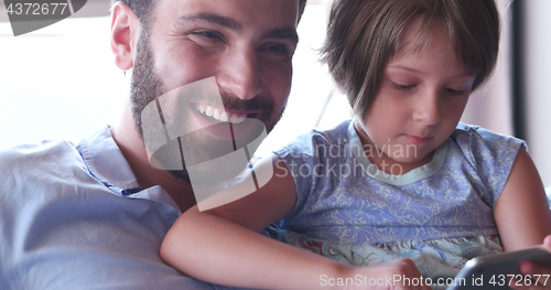 Image of Father Daughter using Tablet in modern apartment