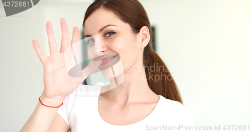 Image of woman sending kiss to camera in modern apartment