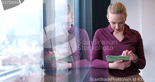 Image of woman manager using cell telephone in office interior