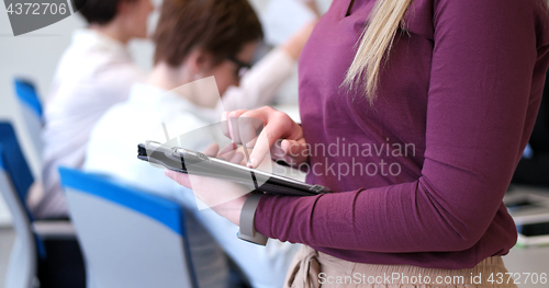 Image of Pretty Businesswoman Using Tablet In Office Building during conf