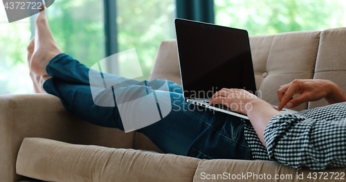 Image of Man using laptop in living room