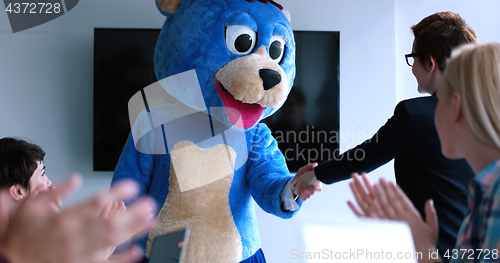 Image of boss dresed as bear having fun with business people in trendy of