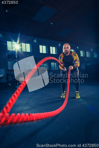 Image of Men with battle rope battle ropes exercise in the fitness gym. CrossFit.