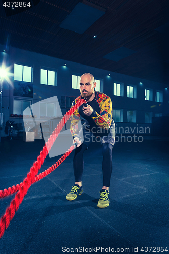 Image of Men with battle rope battle ropes exercise in the fitness gym. CrossFit.