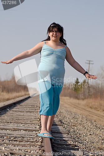 Image of Girl Balancing On Railroad Tracks