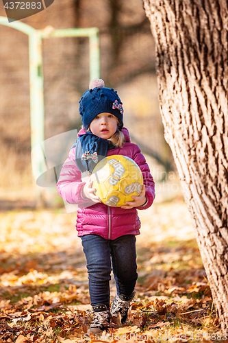 Image of The little baby girl playing in autumn leaves