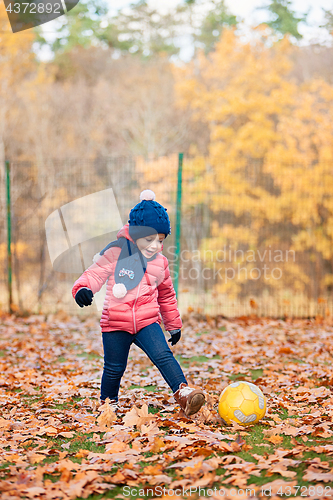 Image of The little baby girl playing in autumn leaves