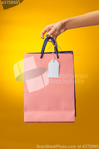 Image of Female hand holding bright shopping bags