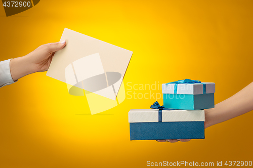Image of The closeup picture of man and woman\'s hands with gift box