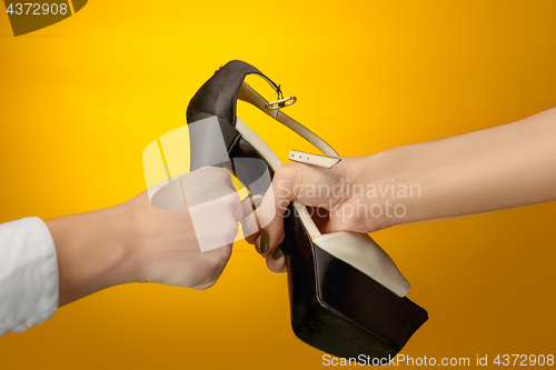 Image of Brown woman shoe with female and male on hands