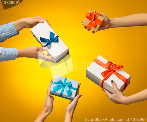 Image of The closeup picture of man and woman\'s hands with gift box