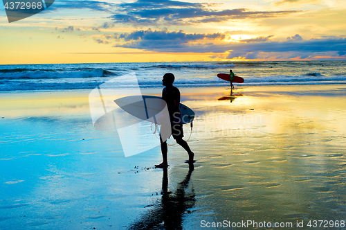 Image of Surfers walking on the beach