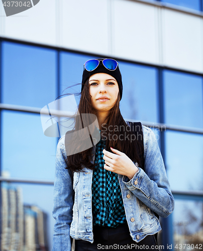 Image of young pretty girl near business building walking