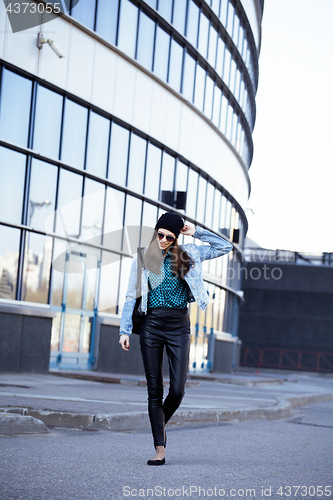 Image of young pretty girl near business building walking