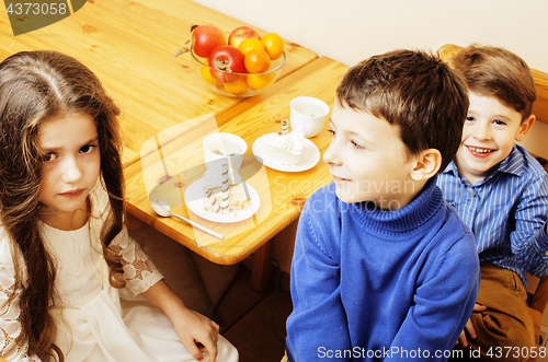 Image of little cute boys eating dessert on wooden kitchen. home interior