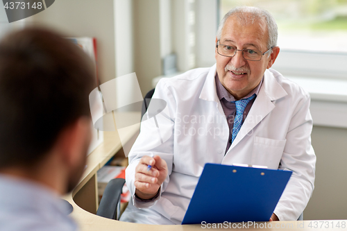 Image of senior doctor talking to male patient at hospital