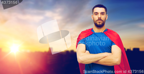 Image of man in red superhero cape over city background