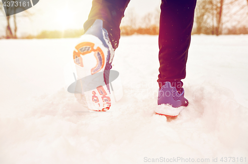 Image of close up of feet running along snowy winter road