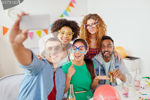 Image of happy team taking selfie at office party