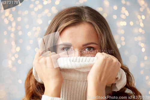 Image of young woman or teen girl pulling pullover collar