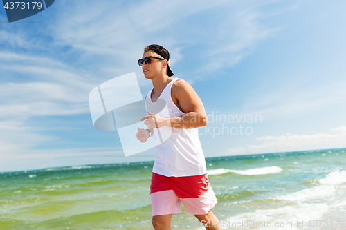 Image of happy man running along summer beach