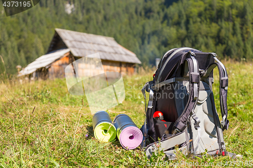 Image of Backpack and yoga mats on mountain meadow.