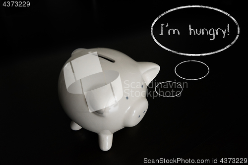 Image of Piggy bank with thought bubbles, thinking I m hungry