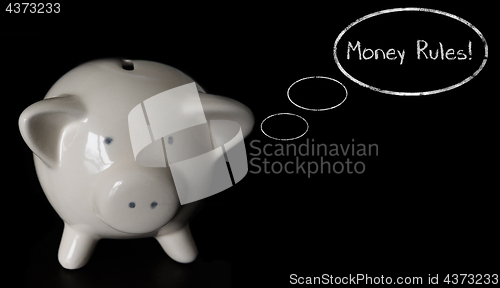 Image of Piggy bank with thought bubbles, thinking MONEY RULES!