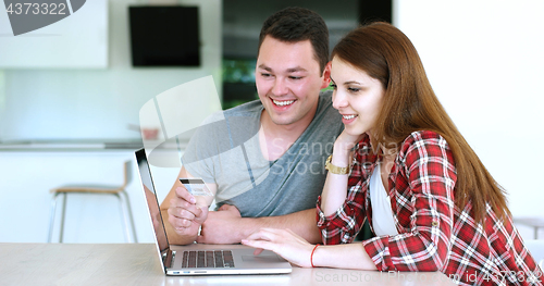 Image of Couple Using Laptop To Shop Online in modern apartment