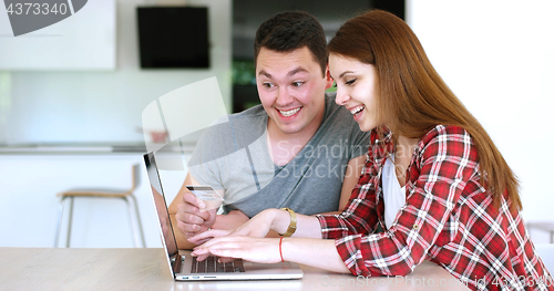 Image of Couple Using Laptop To Shop Online in modern apartment