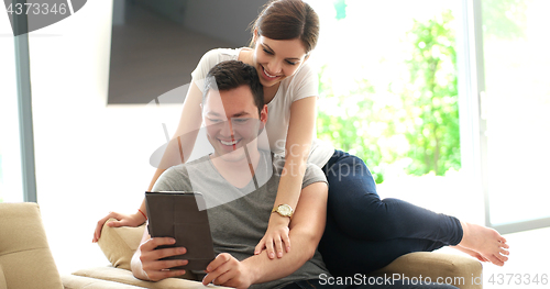 Image of Young Couple using digital tablet at home