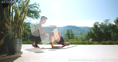 Image of Couple Doing Stretching Exercises Together in front of luxury vi