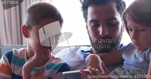 Image of father and two kids having fun together at home