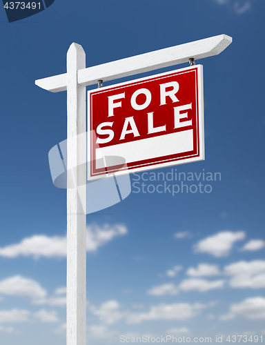 Image of Right Facing For Sale Real Estate Sign on a Blue Sky with Clouds