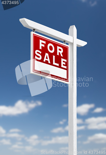 Image of Left Facing For Sale Real Estate Sign on a Blue Sky with Clouds.