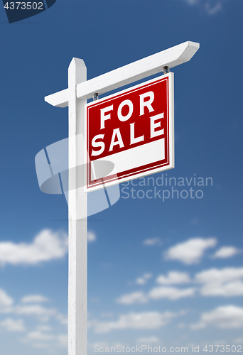 Image of Right Facing For Sale Real Estate Sign on a Blue Sky with Clouds