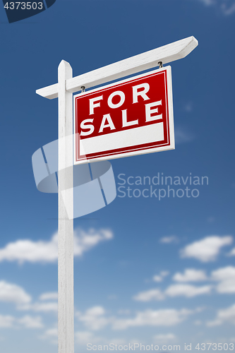 Image of Right Facing For Sale Real Estate Sign on a Blue Sky with Clouds