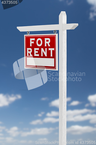 Image of Left Facing For Rent Real Estate Sign on a Blue Sky with Clouds.