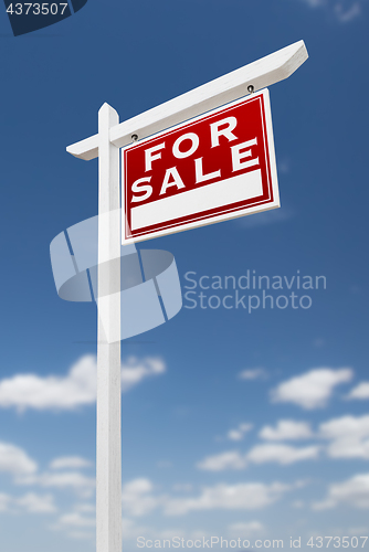 Image of Right Facing For Sale Real Estate Sign on a Blue Sky with Clouds