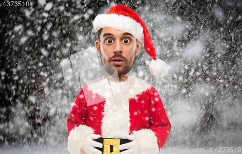 Image of man in santa claus costume over christmas snow