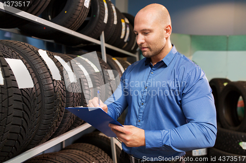 Image of auto business owner and wheel tires at car service