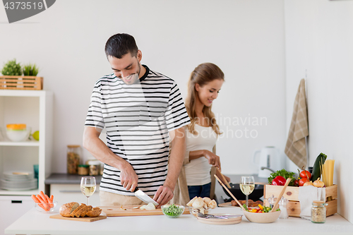 Image of couple cooking food at home kitchen