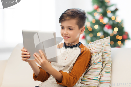 Image of smiling boy with tablet pc at home at christmas