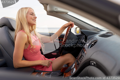 Image of happy young woman in convertible car