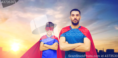 Image of father and son in superhero capes over city